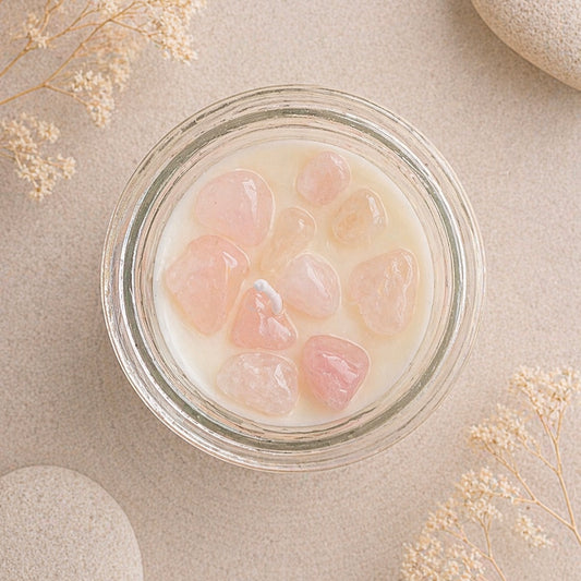 Glass jar with rose quartz crystal chips on a beige surface with dried flowers