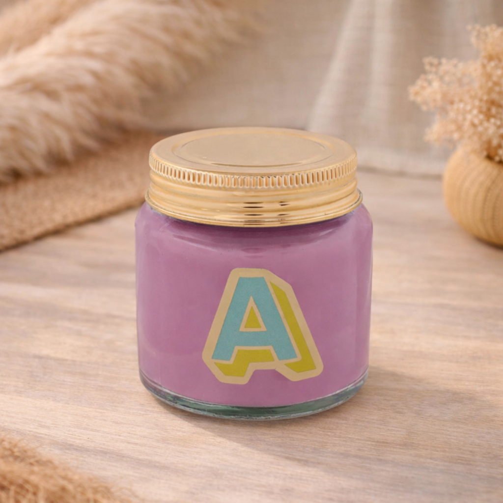 Personalised colour pop letter a candle jar with pueple wax and gold lid on bohemian background