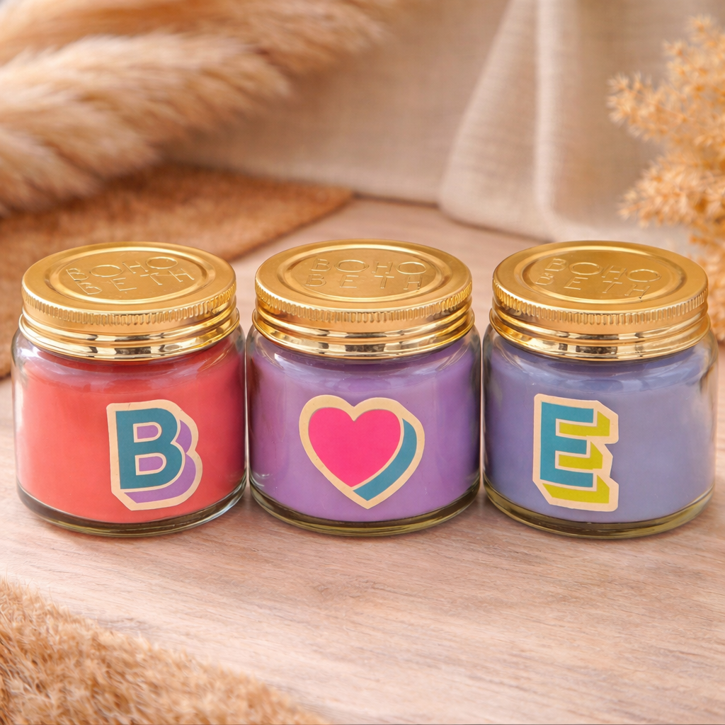 Personalised colour pop letter and heart candle jars with pastel wax and gold lids styled in a bohemian setting