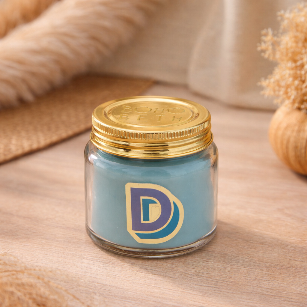 Personalised colour pop letter d candle jar with turquoise wax and gold lid on bohemian background