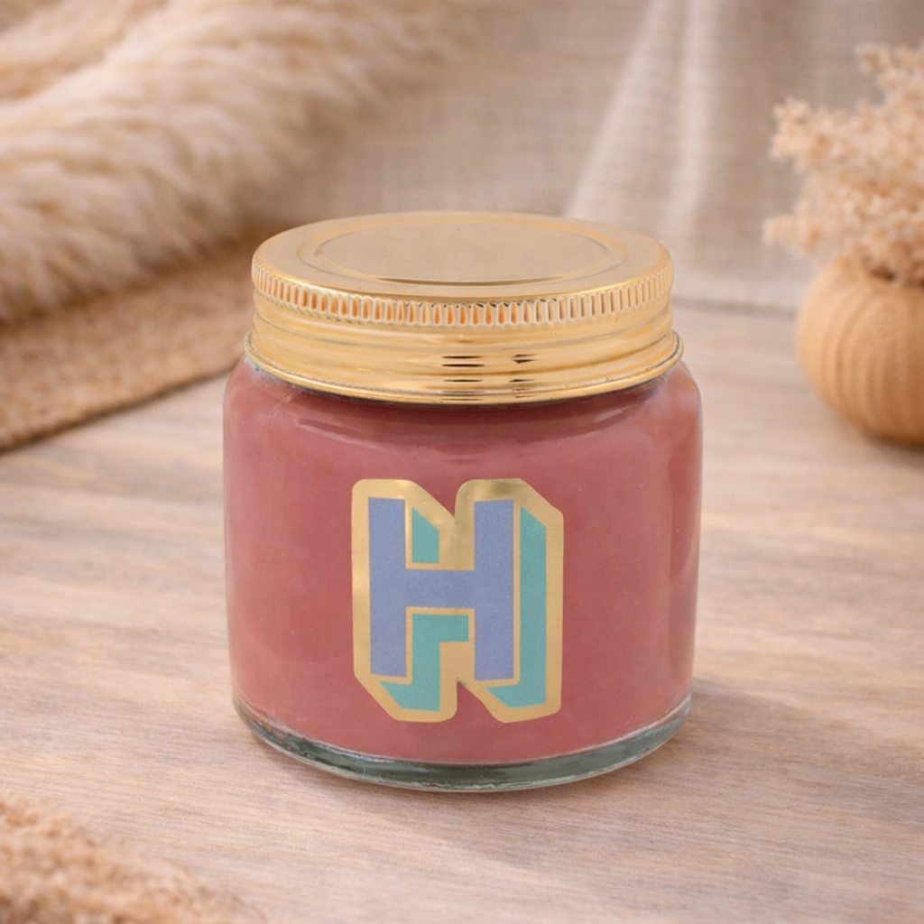 Personalised colour pop letter h candle jar with pastel wax and gold lid on bohemian background