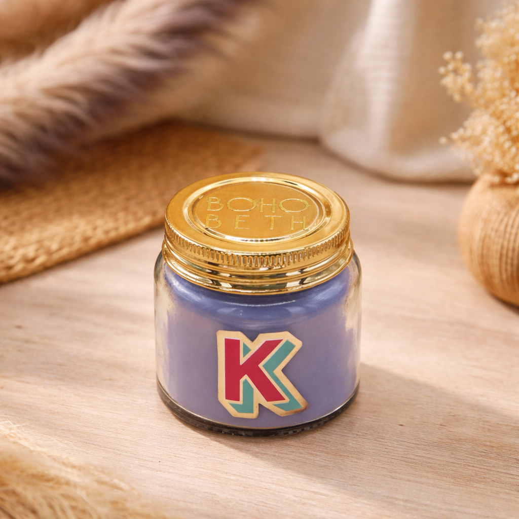 Personalised colour pop letter k candle jar with pastel wax and gold lid on bohemian background