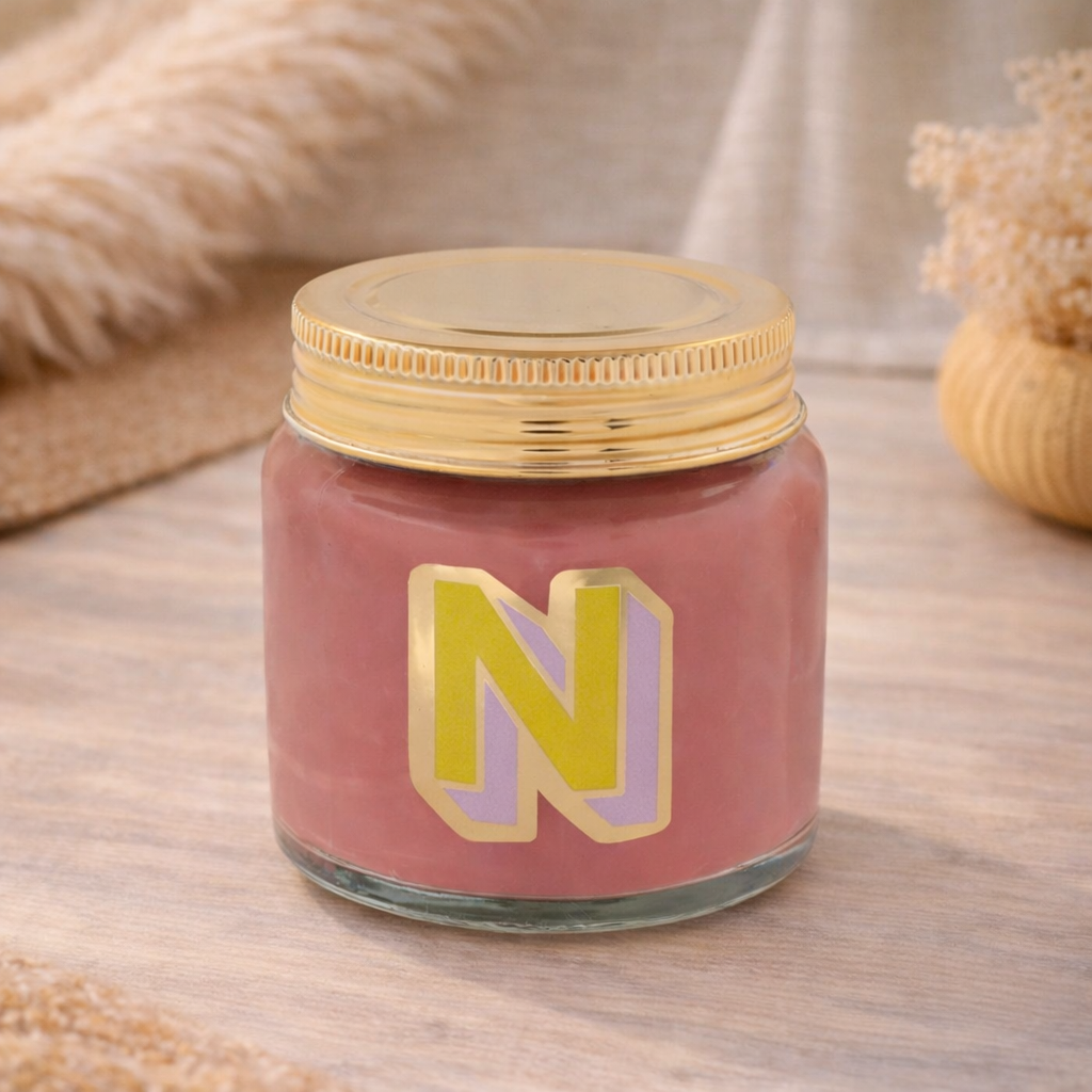 Personalised colour pop letter n candle jar with pastel wax and gold lid on bohemian background