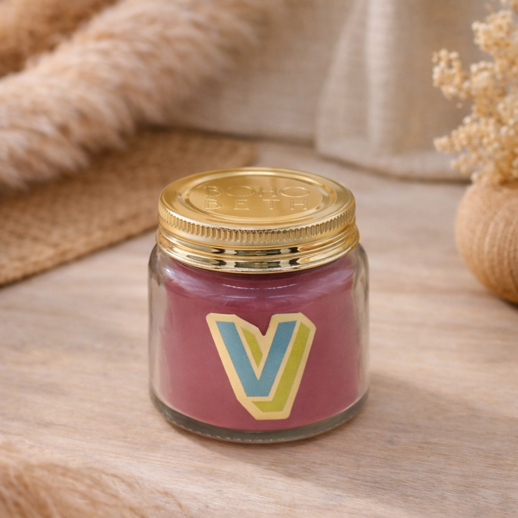 Personalised colour pop letter v candle jar with pastel wax and gold lid on bohemian background
